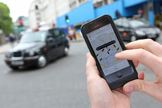 A user scans for an available vehicle using the Uber Technologies’ app on a smartphone in London.   Bloomberg