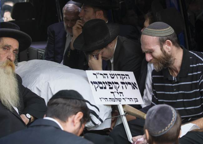 Ultra-Orthodox Jews mourn near the body of one of the victims of an attack by two Palestinians during a funeral in Jerusalem on Tuesday.   AFP-Yonhap