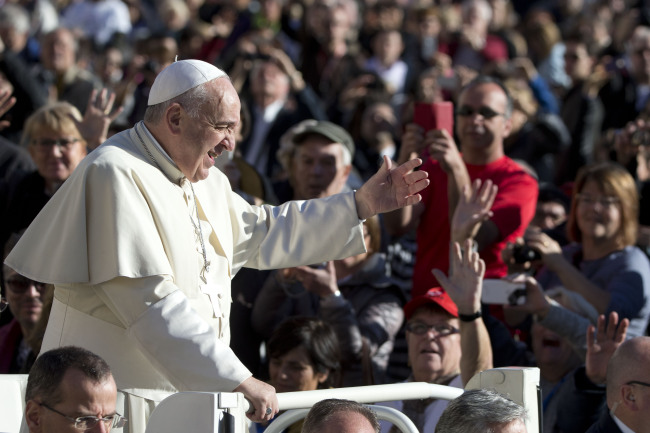Pope Francis waves to faithful as he arrives for his weekly general audience in St. Peter’s Square at the Vatican on Wednesday.   AP-Yonhap
