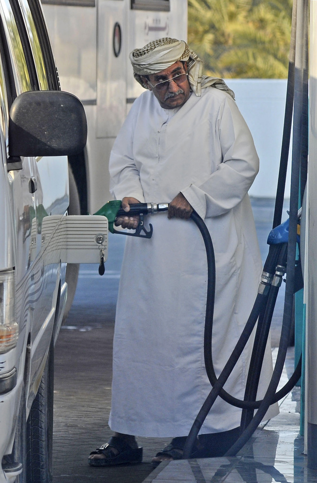 A customer fills his vehicle with fuel at a gas station in Dubai.   Bloomberg