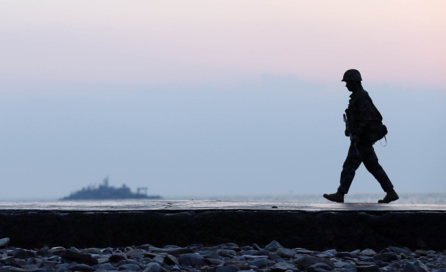 A marine troop conducts a coastal defense mission on Yeongpyeongdo Island near the inter-Korean sea border on Thursday, three days before the fourth anniversary of the North’s artillery attack on the island.   Yonhap
