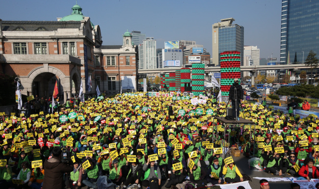 Nonregular school workers shout slogans Thursday in front of Seoul Station during their two-day strike, in which they demanded to be hired as full-time staff while receiving paid vacation and lunch breaks.   Yonhap