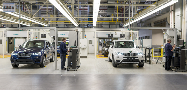 Workers inspect new cars at the testing line of the Spartanburg plant in South Carolina.   BMW Group