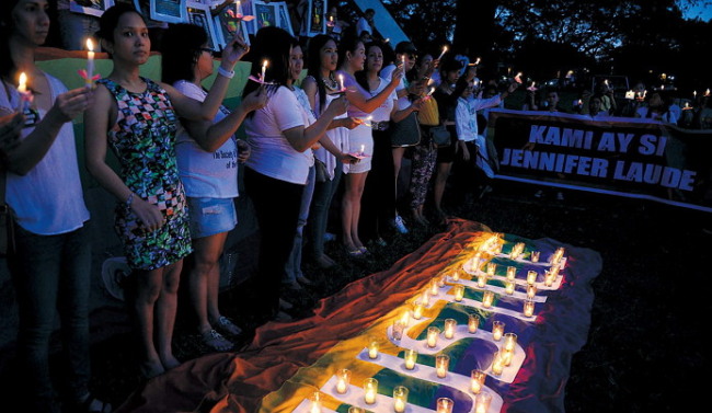This photo shows members and supporters of Manila’s lesbian, gay, bisexual and transgender community attending a candle vigil during a protest at the state university, against the killing of a Filipino transgender woman allegedly by a U.S. marine. (AFP-Yonhap)