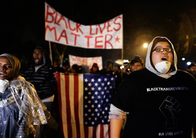 Demonstrators shout slogans during a march in St. Louis, Missouri, Sunday to protest the death of 18-year-old Michael Brown. More than 100 protesters marched peacefully through St. Louis, stepping up pressure on a grand jury to indict a white police officer for shooting dead an unarmed black teenager. (Related story on Page 6)    AFP-Yonhap
