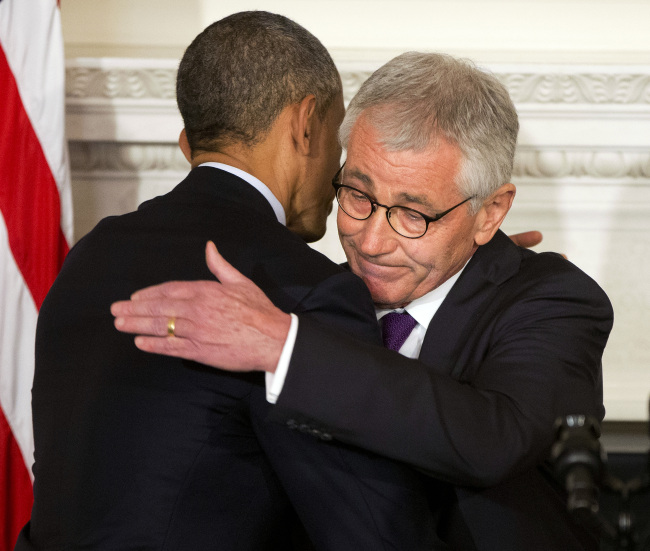 President Barack Obama (left) and Defense Secretary Chuck Hagel embrace after speaking about Hagel’s resignation during an event in the State Dining Room of the White House in Washington on Monday.   AP-Yonhap