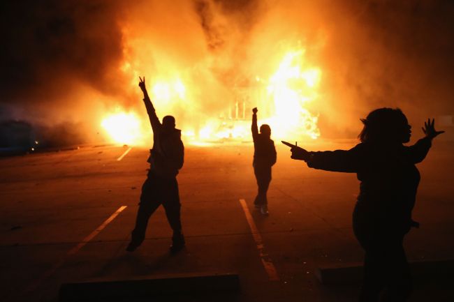 Demonstrators celebrate as a business burns after it was set on fire during rioting following the grand jury announcement in the Michael Brown case in Ferguson, Missouri, Monday. Ferguson has been struggling to return to normal after Brown, an 18-year-old black man, was killed by Darren Wilson, a white Ferguson police officer, on Aug. 9.  AFP-Yonhap