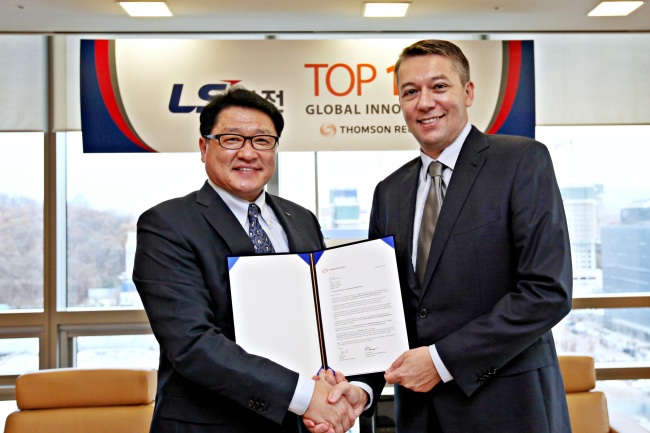 LSIS CEO Koo Ja-kyun (left) poses with Tony Kinnear, managing director of ASEAN and North Asia at Thomson Reuters, at an awards ceremony at LS Tower in Anyang, Gyeonggi Province.