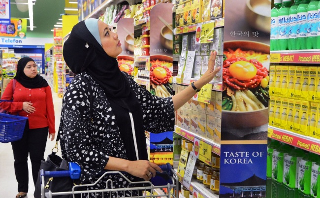 A shopper looks around the Korean food section at the Mutiara Damansara Tesco Extra Store in Kuala Lumpur, Malaysia.   Homeplus