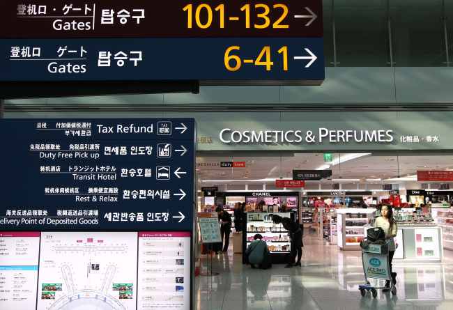 A traveler pushes her luggage in front of the cosmetics and perfumes section of the duty-free shopping area at Incheon International Airport. Incheon International Airport Corp. launched a bid for new duty-free business licenses Friday.   Bloomberg