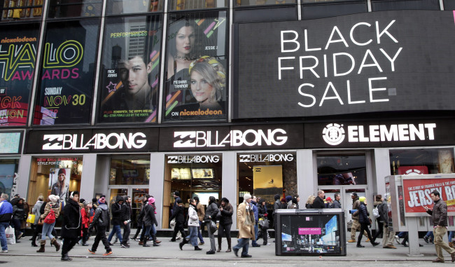 Shoppers holding bags walk through Times Square on Black Friday in New York on Friday.   UPI-Yonhap