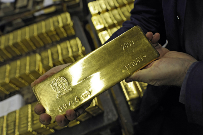 An employee shows a gold bar at the Argor-Heraeus gold producing and refining plant in Mendrisio, Switzerland.   Bloomberg