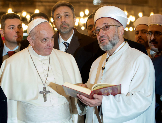 <YONHAP PHOTO-0423> In this photo provided by Vatican newspaper L'Osservatore Romano, Grand Mufti of Istanbul, Rahmi Yaran, right, shows Pope Francis the Quran, the Muslim holy book, at the Sultan Ahmet mosque in Istanbul, Turkey, Saturday, Nov. 29, 2014. Meeting with Turkish leaders in the capital Ankara a day earlier, Francis urged Muslim leaders to condemn the "barbaric violence" being committed in Islam's name against religious minorities in Iraq and Syria. (AP Photo/L'Osservatore Romano)/2014-11-30 05:39:13/ <저작권자 ⓒ 1980-2014 ㈜연합뉴스. 무단 전재 재배포 금지.>
Grand Mufti of Istanbul, Rahmi Yaran (right), shows Pope Francis the Quran, the Muslim holy book, at the Sultan Ahmet mosque in Istanbul, Turkey, Saturday.   AP-Yonhap