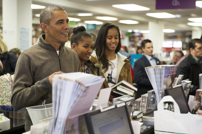 U.S. President Barack Obama (left) shops with his daughters, Sasha (center) and Malia, at Politics and Prose on “Small Business Saturday” in Washington on Saturday.   AP-Yonhap