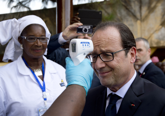 French President Francois Hollande has his temperature taken upon his arrival at the Donka hospital in Conakry, Guinea, Friday, as part of a one-day visit focused on the Ebola situation.   AP-Yonhap