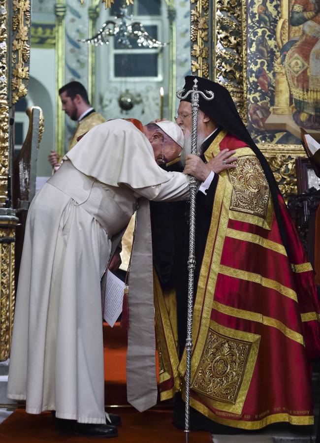 Ecumenical Patriarch Bartholomew I (right) kisses Pope Francis’ head during an ecumenical prayer at the Patriarchal Church of St. George in Istanbul, Saturday. The two major branches of Christianity represented by Bartholomew and Francis split in 1054 over differences on the power of the papacy. The two spiritual heads will participate in an ecumenical liturgy and sign a joint declaration in the ongoing attempt to reunite the churches. (Related story on Page 18)   AP-Yonhap