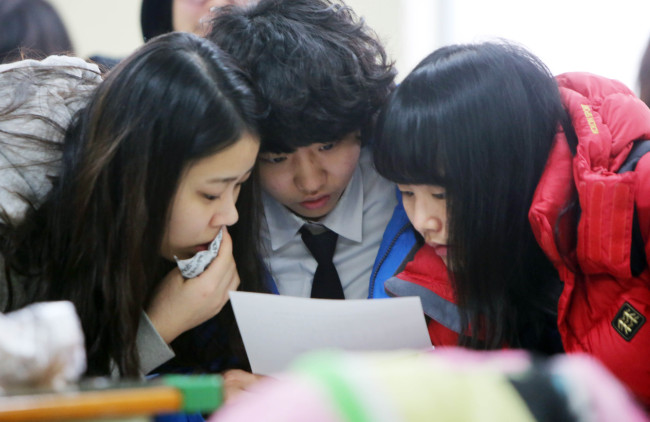 Seniors at Dunwon High School in Daejeon check their scores on the college entrance exam on Wednesday. The annual exam, which plays a critical role in college admission, took place on Nov. 13.   Yonhap