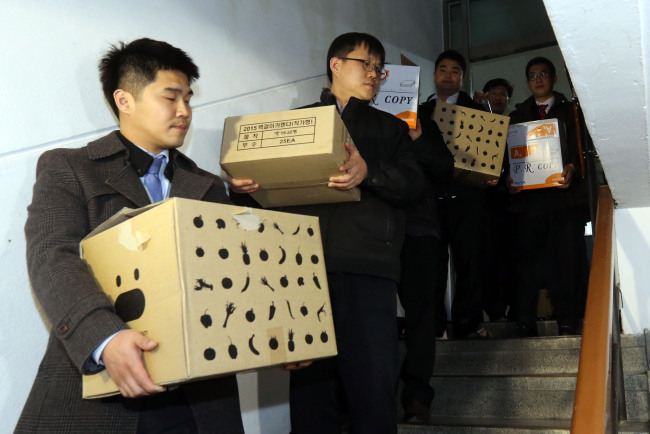 Prosecution investigators hold boxes containing documents after searching the Seoul Metropolitan Police Agency on Wednesday. (Yonhap)