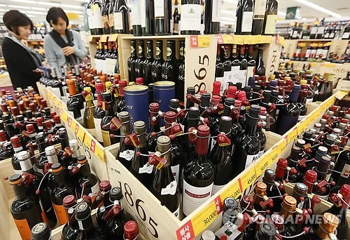 Customers take a close look at a collection of wines in a wine section at a local supermarket chain in Seoul.   Yonhap