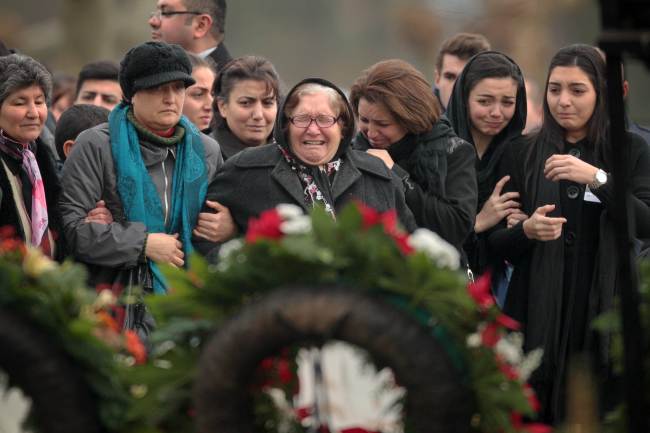 Mourners cry as they stand in front of the grave of Tugce Albayrak during her burial at the cemetery in Bad Soden-Salmnster, western Germany, Wednesday.   AFP-Yonhap