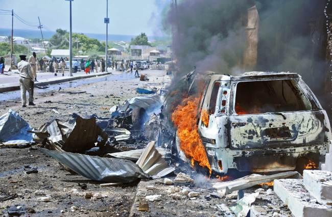 A car burns following a blast near the heavily fortified gates of the airport in Mogadishu on Wednesday.   AFP-Yonhap