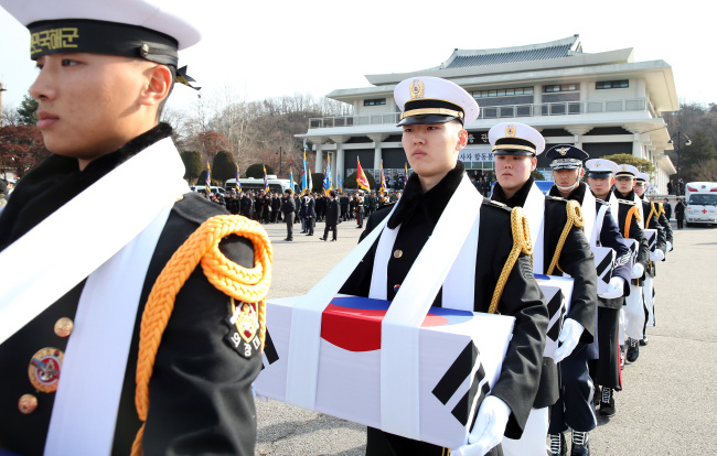 Military officials on Thursday carry the remains of South Korean soldiers who died in the 1950-53 Korean War at a joint memorial service in Seoul National Cemetery. A total of 818 deceased soldiers whose identities were unidentified were honored in the ceremony.   Yonhap