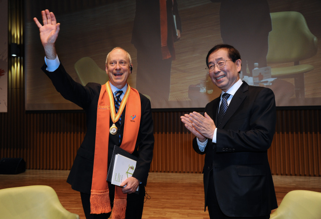 Michael Sandel (left), an American political philosopher and a professor at Harvard University, poses for a photo after receiving an honorary citizenship of Seoul from Seoul Mayor Park Won-soon at City Hall on Friday.   Seoul Metropolitan Government