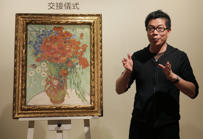 Chinese movie mogul and chairman and CEO of Huayi Brothers Media Corp., Wang Zhongjun, speaks during a ceremony to receive the painting of Vincent van Gogh’s “ Vase with Daisies and Poppies” at the Sotheby’s auction house in Hong Kong on Saturday.   AP-Yonhap