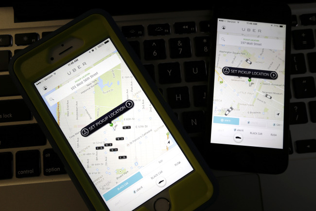Smartphones display Uber car availability in New York.   AP-Yonhap