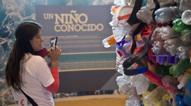 A volunteer takes a picture of a representation of plastics pollution of rivers and oceans that affect the planet in the Ocean Pavilion on the sidelines of the U.N. COP20 and CMP10 conferences in Lima on Wednesday.   AFP-Yonhap