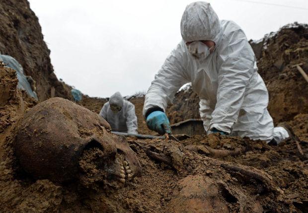 An archaeologist excavates remains of one of more than 2,500 Soviet and Italian soldiers from World War II who died in a Nazi German stalag near the city of Przemysl on Nov. 28. (AFP)