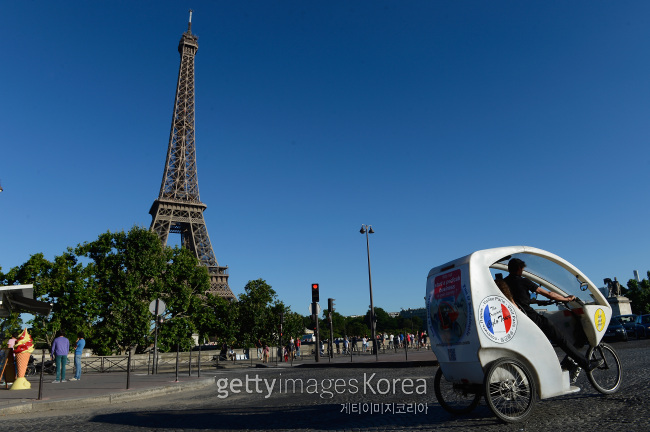 파리 에펠탑 거리를 지나고 있는 자전거 택시. [사진 =게티이미지]
파리 에펠탑 거리를 지나고 있는 자전거 택시. [사진 =게티이미지]