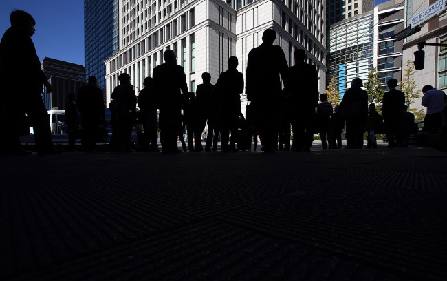 Pedestrians wait to cross a road in Tokyo, Japan, on Wednesday, Nov. 19, 2014. Japan's Topix index rose after Prime Minister Shinzo Abe postponed a planned sales-tax increase, called a snap election and ordered his ministers to start preparing a stimulus package. Photographer: Tomohiro Ohsumi/Bloomberg
Pedestrians wait to cross a road in Tokyo.   Bloomberg
