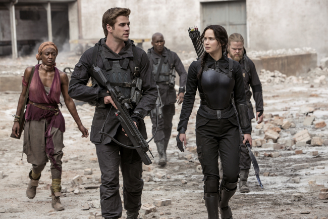 Jennifer Lawrence portrays Katniss Everdeen (right) and Liam Hemsworth portrays Gale Hawthorne in a scene from “The Hunger Games: Mockingjay ― Part 1.”   AP-Yonhap