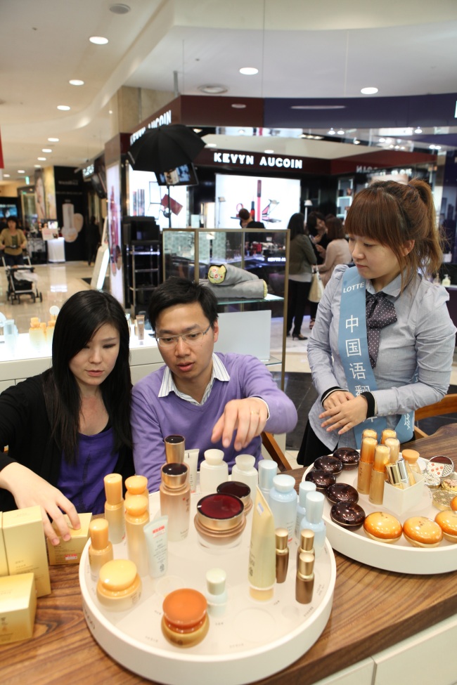 Chinese tourists shop for high-end cosmetics at Lotte Department Store in Myeong-dong, Seoul.   Lotte Department