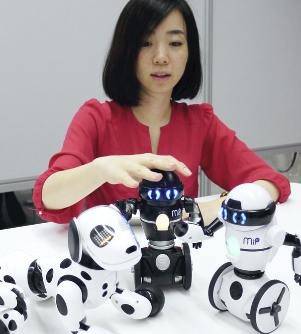 Tomy Co.’s robot dog “Hello! Zoomer” (left) and two humanoid robots, “Hello! Mip” (center and right).