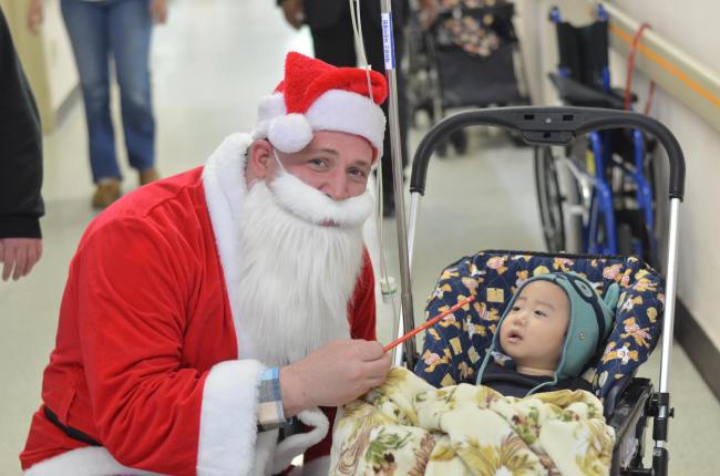 A volunteer dressed as Santa visits a baby in the cancer ward of Severance Hospital in Seoul during a volunteering event held last year by HOPE.   HOPE
