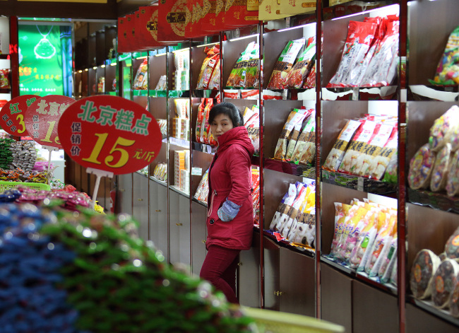 A salesclerk waits for customers at a store selling packaged foods on Qianmen Street in Beijing, China, on Sunday, Nov. 9, 2014. President Xi Jinping signaled China is ready to accept a lower rate of growth, assuring executives that the economy is more resilient than ever and his government can safely guide the country through any slowdown. Photographer: Tomohiro Ohsumi/Bloomberg
A sales clerk waits for customers at a store selling packaged foods on Qianmen Street in Beijing.   Bloomberg
A sales clerk waits for customers at a store selling packaged foods on Qianmen Street in Beijing.   Bloomberg