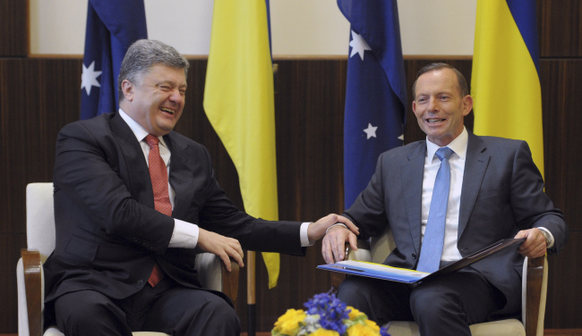 Ukrainian President Petro Poroshenko (left) and Australian Prime Minister Tony Abbott share a laugh as they meet at the federal government office in Melbourne, Australia, Thursday.   AP-Yonhap