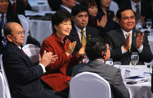 President Park Geun-hye, Myanmar President Thein Sein (left) and Thai Prime Minister Prayuth Chan-o-cha (right) applaud during a speech by Korea Chamber of Commerce and Industry chairman Park Yong-maan at the ASEAN-Korea CEO Summit at BEXCO in Busan on Thursday.   Yonhap