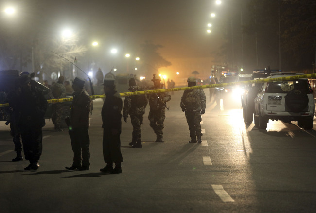 Afghan security forces walk around the French Cultural Center which was targeted by a suicide attacker in Kabul on Thursday.   AP-Yonhap
