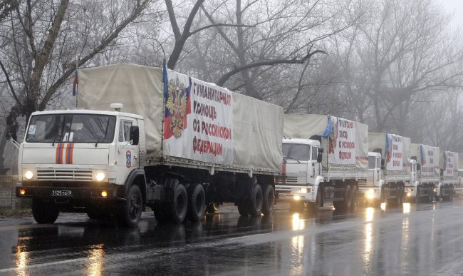 Trucks from a Russian aid convoy carrying banners reading “Humanitarian help from Russian Federation” drive near Donetsk, Ukraine, Friday.   EPA-Yonhap