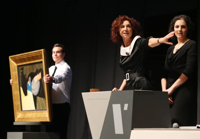 Judit Virag (center) speaks during an auction at the Judit Virag Gallery in Budapest on Saturday, next to the painting “Sleeping Woman with Black Vase” of Hungarian artist Robert Bereny. AFP-Yonhap