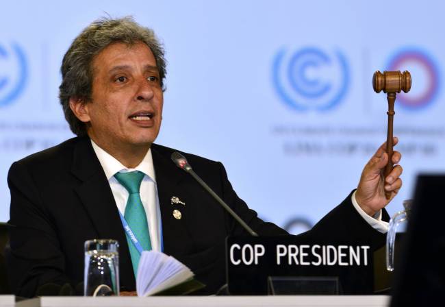 Peruvian Minister of Environment Manuel Pulgar slams his mallet to approve and close the discussion on a proposed compromise document handed out during the U.N. talks in Lima on Sunday.   AFP-Yonhap