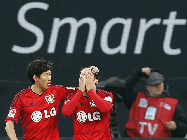 Leverkusen’s Hakan Calhanoglu (right) celebrates with teammate Son Heung-min after his goal on Sunday.   AP-Yonhap