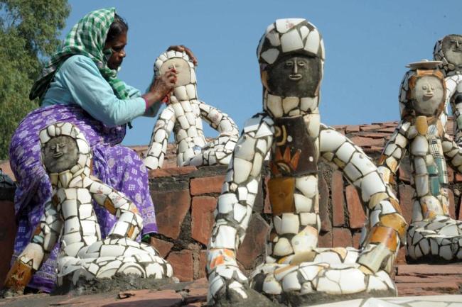 A worker cleans a sculpture at the Rock Garden of Chandigarh built by self-taught Indian artist Nek Chand over the course of 18 years.   AFP