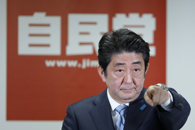 Shinzo Abe, Japan's prime minister and ruling LDP president, points to a journalist as he takes questions during a news conference at the party's headquarters in Tokyo on Monday.  (Bloomberg)