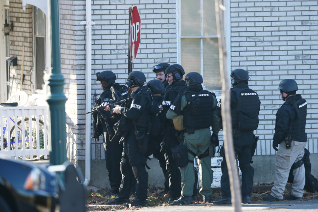 Police gather near a home in Pennsburg, Pennsylvania, Monday, where suspect Bradley William Stone is believed to have barricaded himself inside after shootings at multiple homes.   AP-Yonhap