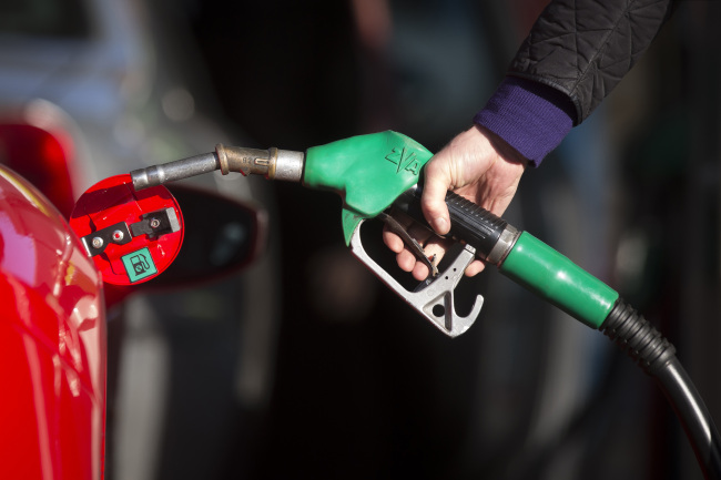 A fuel nozzle is placed into a vehicle at a gas station in Guildford, England.   Bloomberg