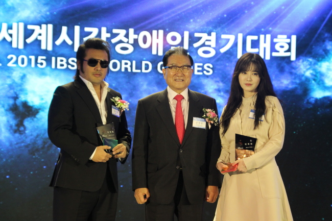 Actor Kim Bo-sung (left) and actress Ku Hye-sun (right) pose with Sohn Byung-doo, president of the Seoul 2015 IBSA World Games organizing committee, after being named goodwill ambassadors for the games in a ceremony at Seoul City Club in Seoul on Tuesday.   Seoul 2015 IBSA World Games